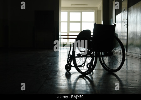 Silhouette de fauteuil roulant vide stationné in hospital hallway Banque D'Images