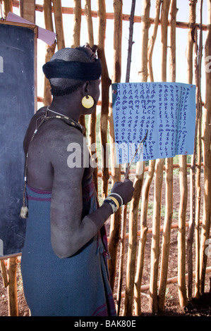 Femme lisant devant l'alphabet de la classe l'Ethiopie Banque D'Images