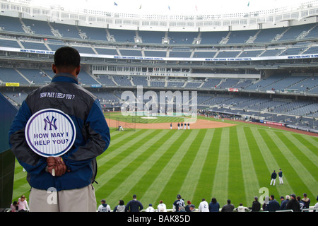 Un travailleur à la recherche sur le champ extérieur au cours de la pratique au bâton au nouveau Yankee Stadium durant la semaine d'Ouverture 2009. Banque D'Images