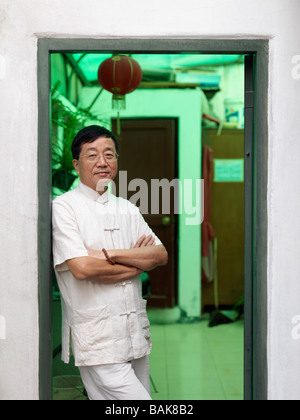 Un portrait d'un homme chinois s'appuyant dans une porte. Banque D'Images