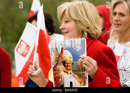 Femme d'âge moyen porte photo de Pape et les vagues d'un drapeau à Chicago Parade polonaise Banque D'Images