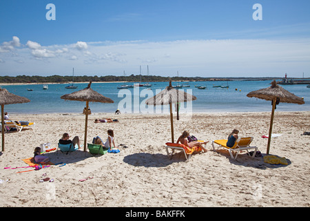 Les gens à l'ombre des parasols sur la plage de Colonia de Sant Jordi Majorque Espagne Banque D'Images