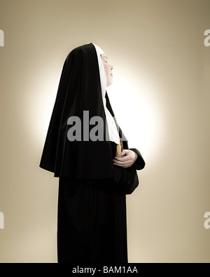 Profil d'une nonne tenant une bible Banque D'Images