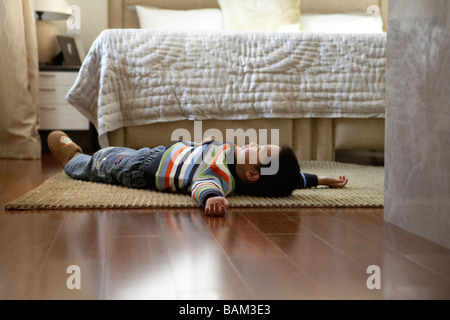 Young Boy Lying On Floor Banque D'Images
