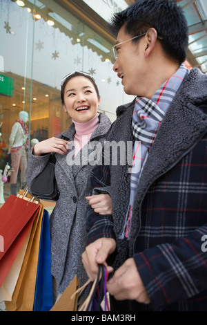 Couple avec bras liés Carrying Shopping Bags Banque D'Images