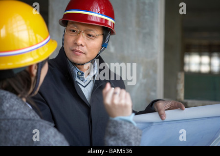 Des entrepreneurs en construction Site Wearing hard hats Banque D'Images