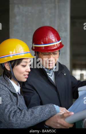 Des entrepreneurs en construction Site Wearing hard hats Banque D'Images