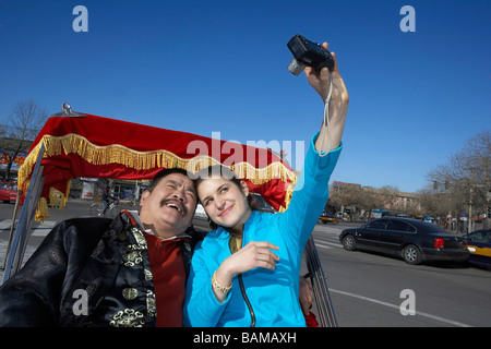 Femme de prendre une photo d'elle-même et un Tuk Tuk Driver Banque D'Images