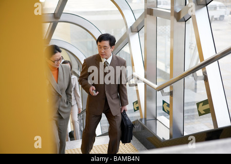 Businessman And Businesswoman Walking Up escaliers du métro Banque D'Images