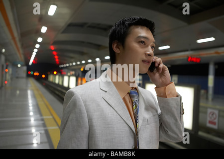 Man Talking On Cellphone In Gare Banque D'Images