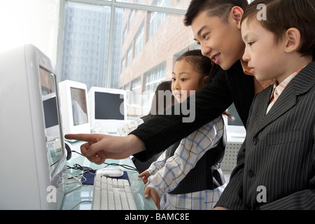 Les jeunes enfants assis à l'ordinateur Banque D'Images