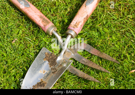 Outils de jardin jardinage truelle à la main et la fourchette portant sur l'herbe Banque D'Images