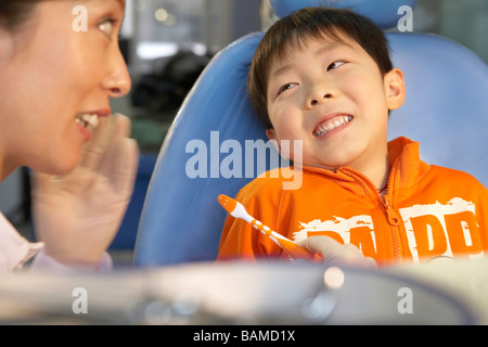 Dentiste souriant à petit garçon avant de se brosser les dents Banque D'Images