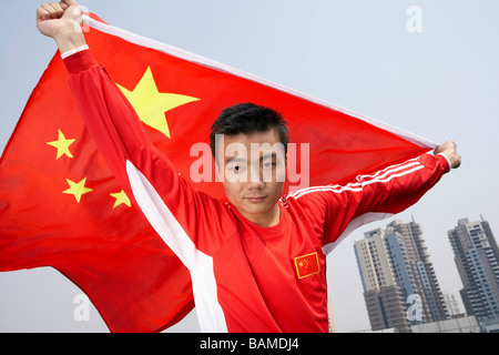 L'athlète chinois tenant le drapeau chinois avec fierté Banque D'Images