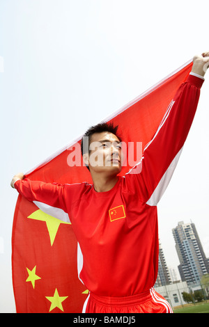 L'athlète chinois tenant le drapeau chinois avec fierté Banque D'Images