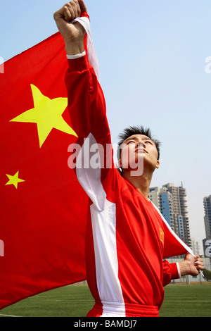 L'athlète chinois tenant le drapeau chinois avec fierté Banque D'Images