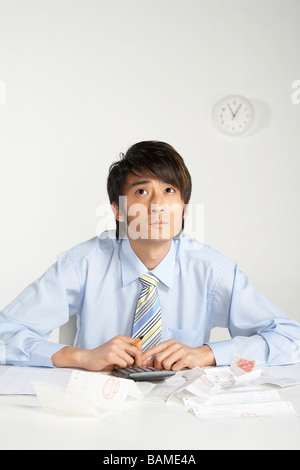 Businessman Using Calculator, regardant pensivement dans la distance Banque D'Images