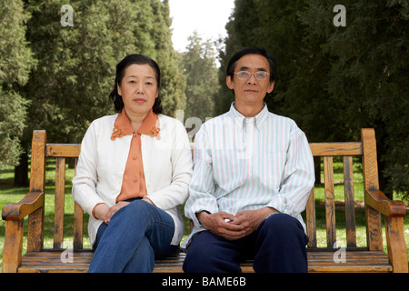 Senior Couple Sitting on Park Bench Ensemble Banque D'Images