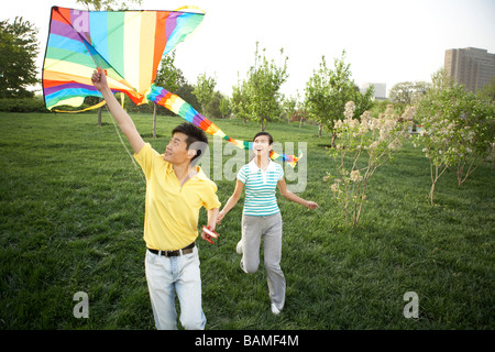Jeune couple Flying Kite In Park Banque D'Images