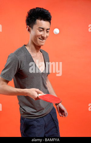 Jeune homme frapper balle de ping-pong Banque D'Images