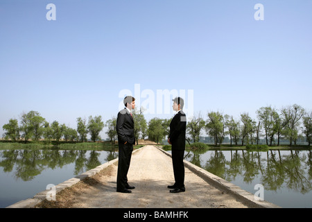 Hommes d'debout près d'un lac sur un pont Banque D'Images