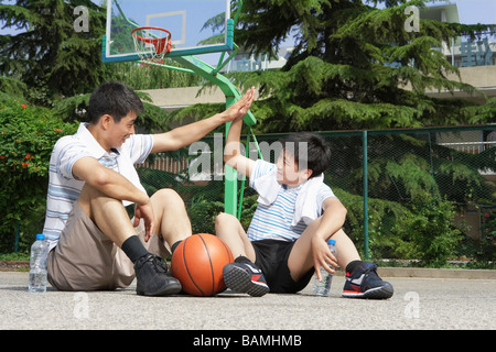 Père et Fils, on subit donc élevé après match de basket-ball Banque D'Images