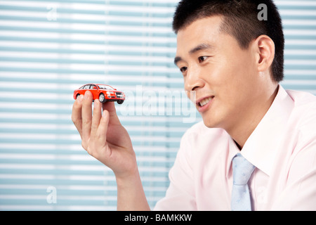 Businessman Holding A Toy Car Banque D'Images