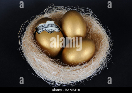 Les oeufs d'or avec de l'argent in Nest Banque D'Images