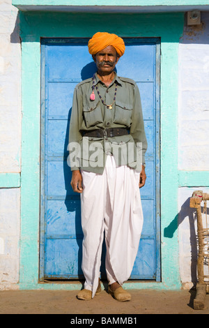 Homme debout à l'extérieur d'une maison peinte en couleurs près de Osian, Rajasthan, Inde Banque D'Images