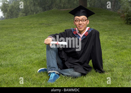 Portrait de jeune homme dans le parc avec l'obtention du diplôme Faire défiler Banque D'Images