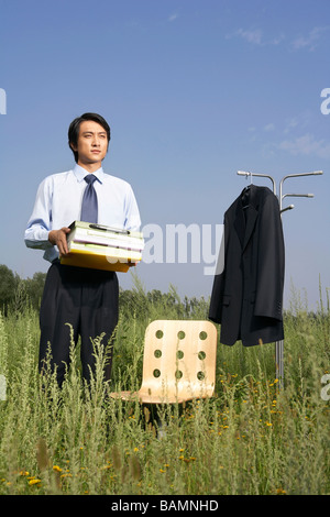 Portrait Of Businessman dans un champ avec des livres Banque D'Images