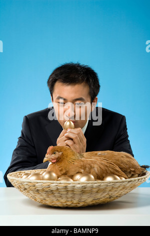 Businessman avec du poulet et des oeufs d'Or Banque D'Images