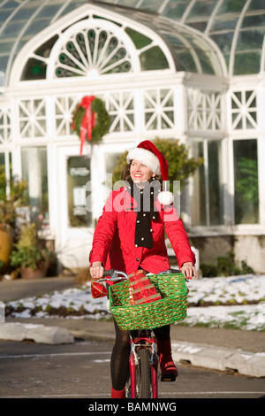 Femme en costume de Noël sur une promenade à vélo Banque D'Images