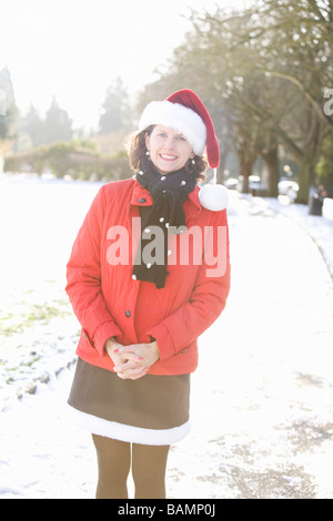 Femme souriante dans un parc portant un chapeau de Noël Banque D'Images