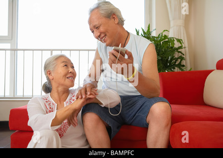 Vieux couple Listening to MP3 Player Ensemble Banque D'Images