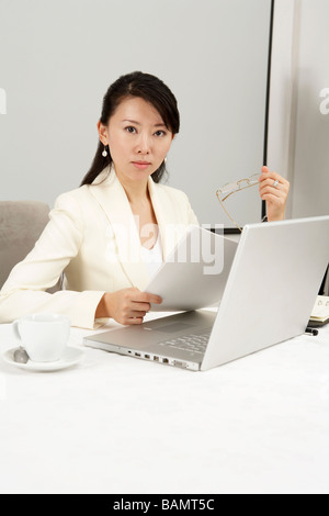 Businesswoman Using Laptop At Dinner Table Banque D'Images