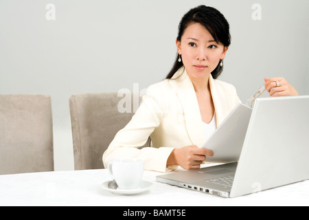 Businesswoman Using Laptop At Dinner Table Banque D'Images