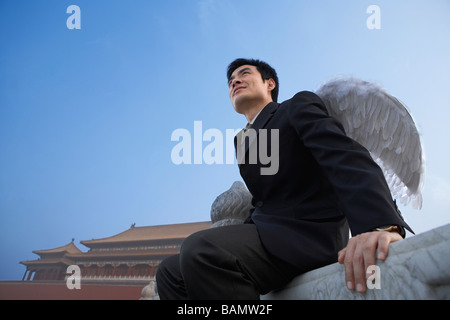 Homme portant des ailes blanches, Looking Pensive Banque D'Images