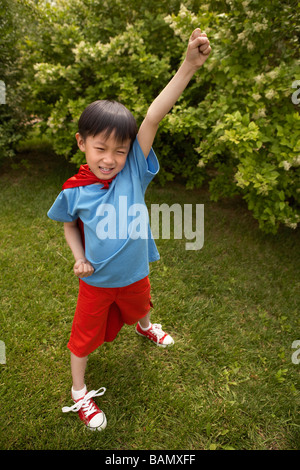 Boy in Cape Rouge Playing In Garden Banque D'Images