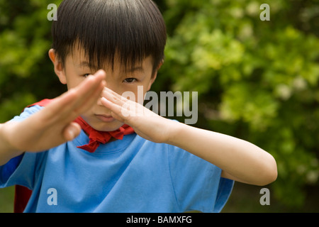 Boy in Cape Rouge Playing In Garden Banque D'Images