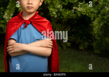 Boy in Cape Rouge Playing In Garden Banque D'Images