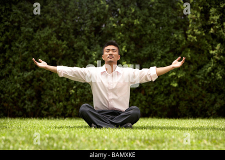 Man Doing Yoga On Grass Banque D'Images