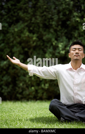 Man Doing Yoga On Grass Banque D'Images