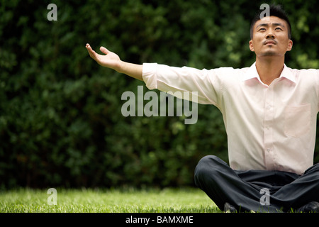 Man Doing Yoga On Grass Banque D'Images