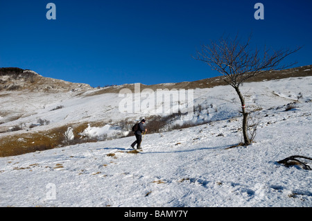 L'alpiniste en vertu de la montagne couverte de neige pendant la journée ensoleillée Banque D'Images
