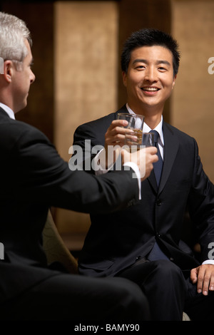 Deux chefs d'entreprise partagent un toast à un club d'affaires exclusif Banque D'Images