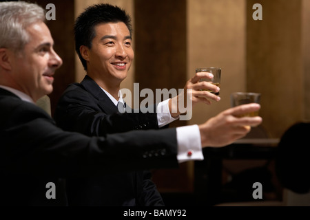 Deux chefs d'entreprise partagent un toast à un club d'affaires exclusif Banque D'Images