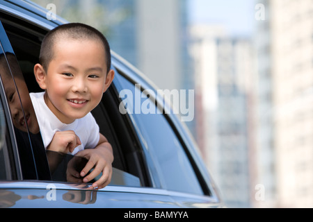 Young boy leaning out car window Banque D'Images