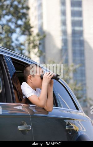 Young boy leaning out car window Banque D'Images