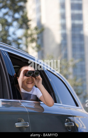 Young boy leaning out car window Banque D'Images